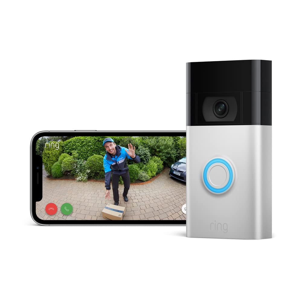 The image shows a smartphone and a Ring Doorbell 2. The smartphone's screen displays a delivery person standing at a doorstep, waving towards the camera with a package by their feet. This suggests that the scene is being captured in real-time by the video doorbell. 