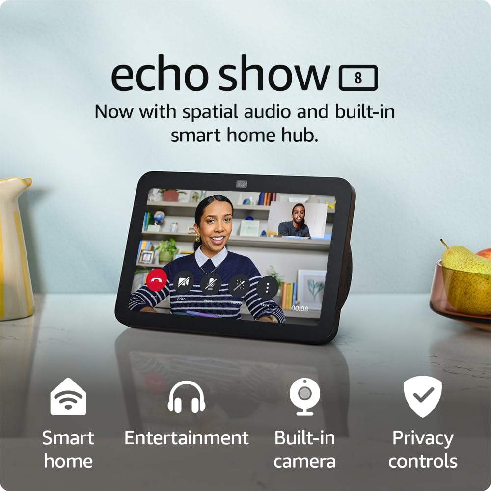 The image is an advertisement for the Echo Show 8, a smart display device that features spatial audio and a built-in smart home hub. In the image, the Echo Show 8 is placed on a surface and is displaying a video call interface with a woman who appears to be having a conversation. There's another small image of a person in the corner of the screen, which indicates that it's a two-way video call. Below the device, there are icons and text highlighting key features of the Echo Show 8: Smart Home, Entertainment, Built-in camera, and Privacy controls. In the background, there's a shelf with some decorative items, and on the same surface as the Echo Show 8, there's a bowl with a pair of pears. The overall setting suggests a comfortable home environment where the Echo Show 8 could be used for various tasks.
