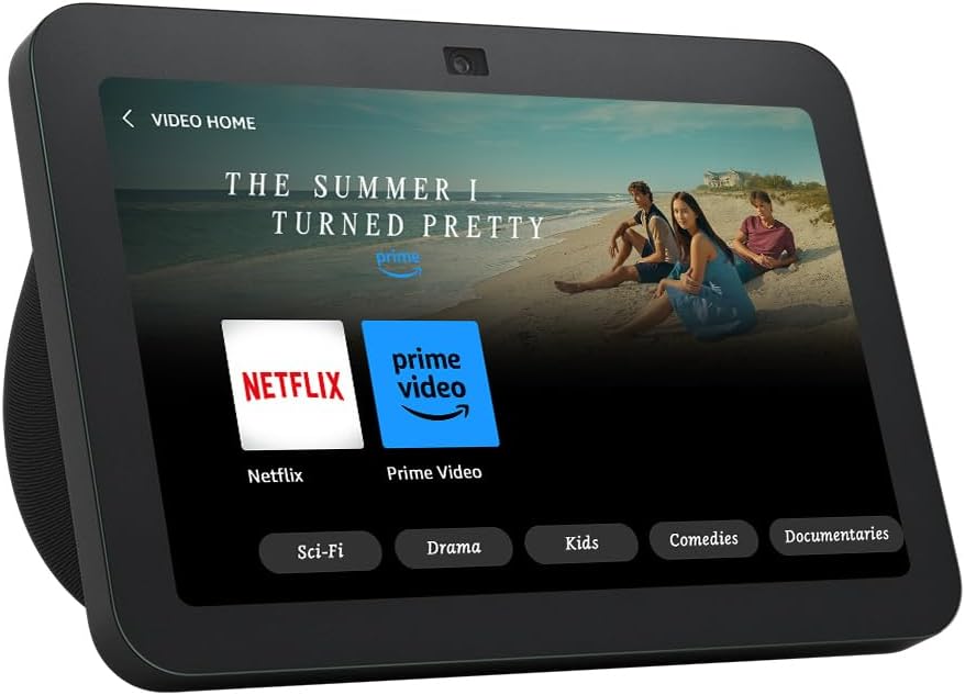 The image shows what appears to be a smart display device featuring a user interface that provides access to various streaming services and content categories. On the screen, there is a featured title called 