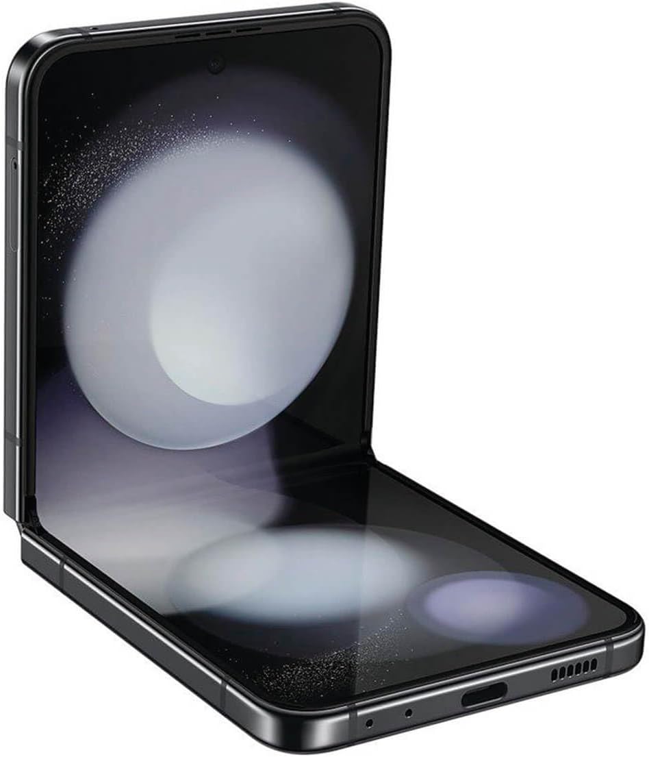 The image shows a foldable Galaxy Z Flip5, partially unfolded, displaying a wallpaper with a celestial or space theme, which gives the impressions of stars or a galaxy. The phone combines a modern aesthetic with advanced technology that allows the screen to fold in half, transforming the device's form factor between a compact phone and a larger-screen tablet-like device. The visible part of the device includes the screen, the hinges, the edges with the frame, and part of the charging port and speaker grilles at the bottom.
