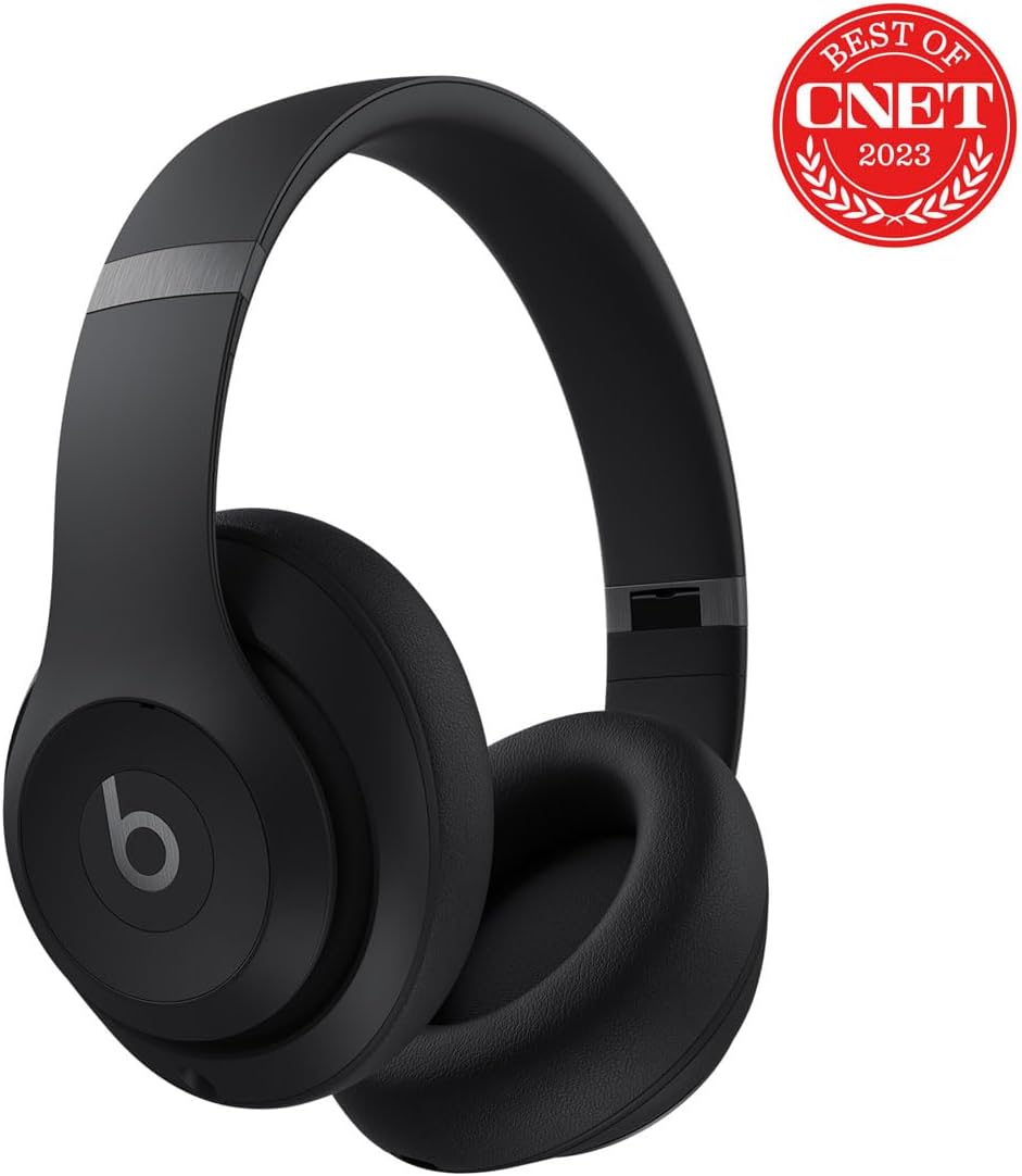 This image shows a pair of black Beats Studio Pro headphones with a prominent 'b' logo on the side, which is the logo for Beats by Dre, a well-known brand of audio equipment. These headphones are designed to cover the entire ear and likely provide noise isolation to improve the listening experience.