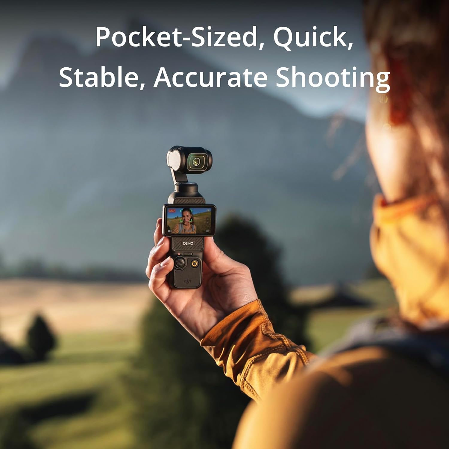 The image features a person holding a compact, handheld gimbal camera with an integrated screen that is displaying an image of the person's face, suggesting it is in selfie mode. The camera appears to be designed for portable and stabilized video shooting.